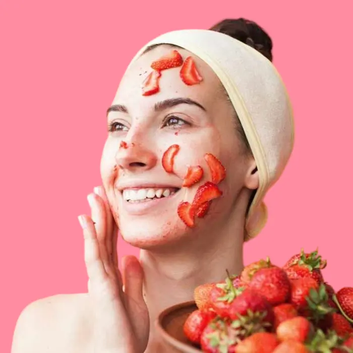 How do strawberries help lighten the skin and reduce pigmentation? 